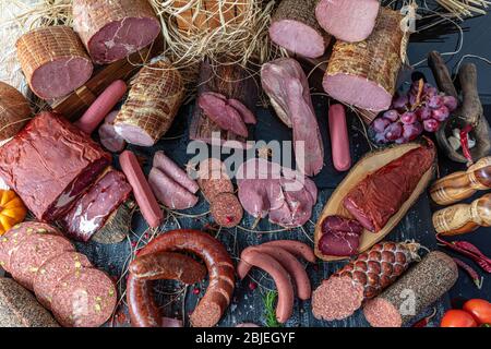 Smoked meat products. Display meats, cold cuts and sausages in a butcher's shop. Assortment of cold meats, variety of processed cold meat products. Stock Photo