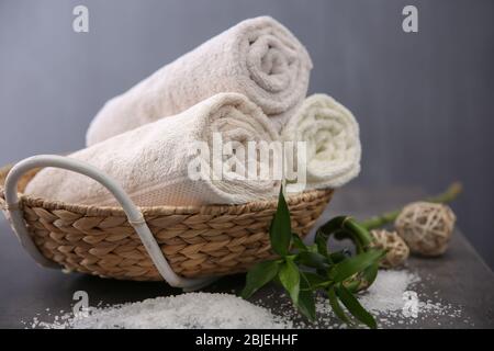 Spa towels in wicker basket on dark background Stock Photo