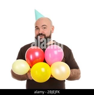 Funny fat man with party hat and colorful balloons on white background Stock Photo