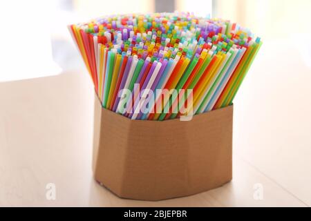 Colorful straws for drinks in box on table Stock Photo