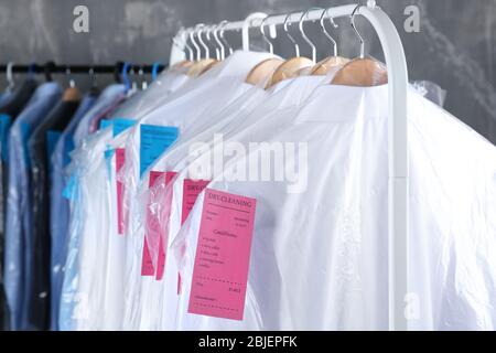 Concept of dry cleaning service. Hangers with clean clothes hanging on rack  Stock Photo - Alamy