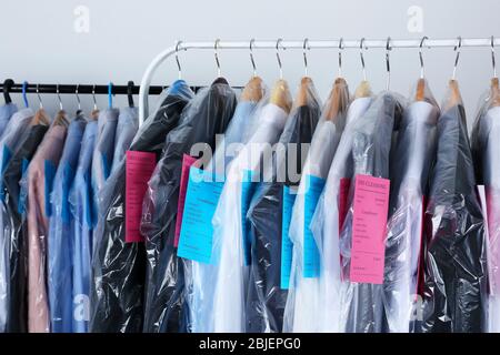 Rack of clean clothes hanging on hangers at dry-cleaning Stock Photo - Alamy