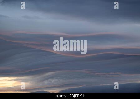 Brooding clouds catching a hint of the setting sun along their edge. Stock Photo