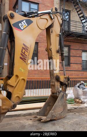Caterpillar brand bulldozer shovel truck parked on a new york street while being used by the city for work. Stock Photo