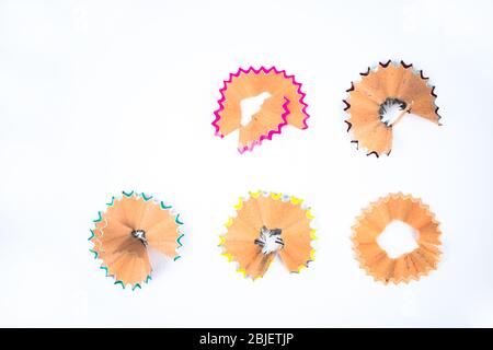 Five different colored pencil shavings placed in front of a white isolated background Stock Photo