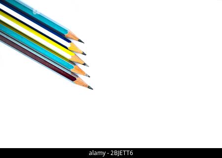 Five different colored wood pencil crayons arranged on a white paper background Stock Photo
