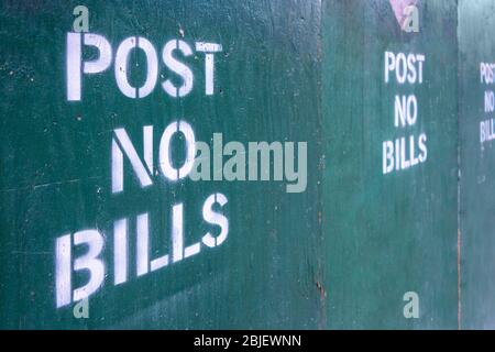 post no bills spray painted text letters on closed off urban construction area Stock Photo