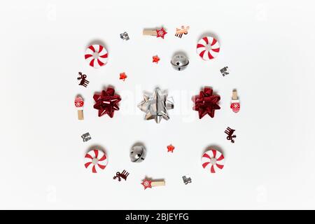 Christmas composition. Round made of clothespins, stars, bows, candy-bulbs, deer confetti and gifts on white background. Horizontal. Minimal style. To Stock Photo