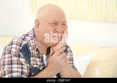 Mature man suffering from pain at home Stock Photo