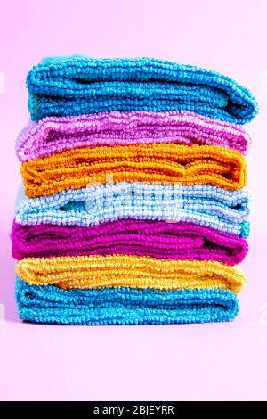 Multi-colored towels on a pink background. Pink, beige, yellow, orange and blue towels. House order Stock Photo