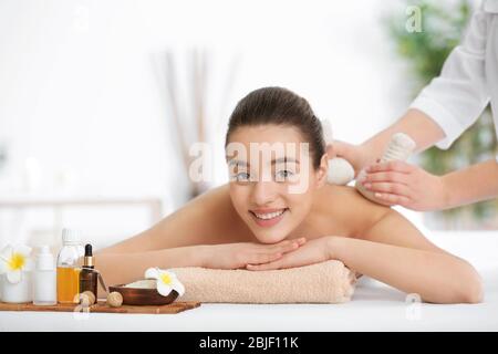 Beautiful young woman receiving massage in spa salon Stock Photo