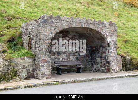 A Wooden Bench Seat in a Stone Built Wind Shelter. Stock Photo