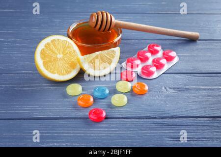 Cough drops with honey and lemon on wooden background Stock Photo