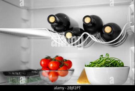 Wine bottles and products in refrigerator Stock Photo