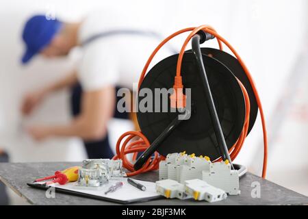 Set of electrician tools and blurred man at work on background Stock Photo