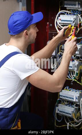 Electrician connecting wires in distribution board Stock Photo