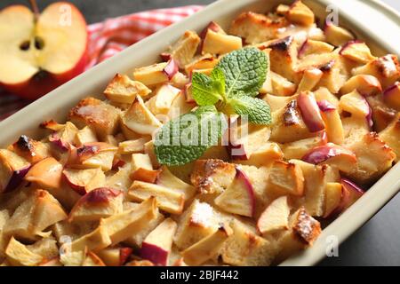 Tasty bread pudding with apples in baking dish, closeup Stock Photo