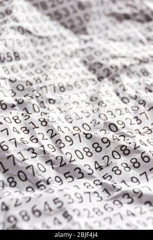 Background with black printed random monospace numbers on crumpled white paper for use as a template for a financial report. Vertical image. Stock Photo