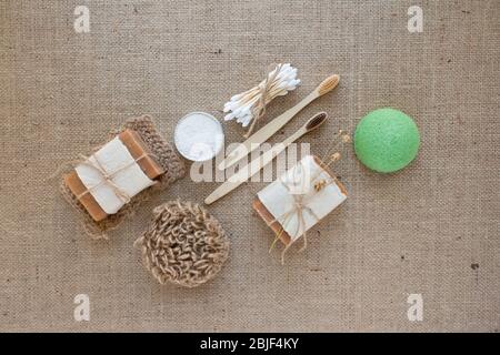 Flat lay composition with natural bathroom essentials, zero waste concept. Ecotools - toothbrushes, bamboo swabs, jute washcloth, facial konjac sponge Stock Photo