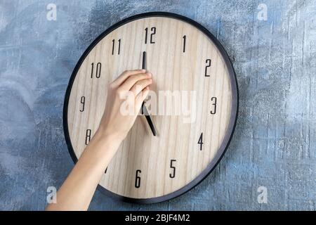 Female hand change time on big wall clock Stock Photo