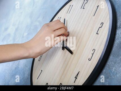 Female hand change time on big wall clock Stock Photo