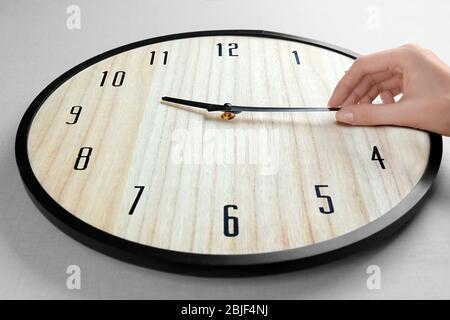 Female hand change time on big wall clock Stock Photo