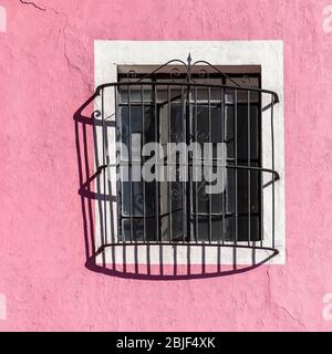 Pink Facade with Window and Wrought Iron Decoration in Puebla, Mexico. Stock Photo