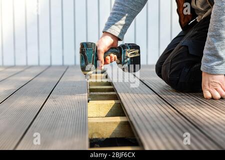 terrace deck construction - man installing wpc composite decking boards Stock Photo