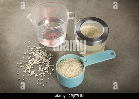 Kitchen ware with rice and water on table Stock Photo