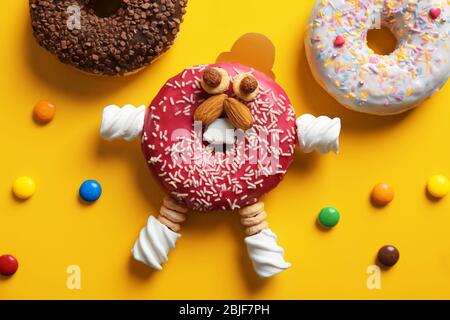 Funny decorated donut on color background Stock Photo