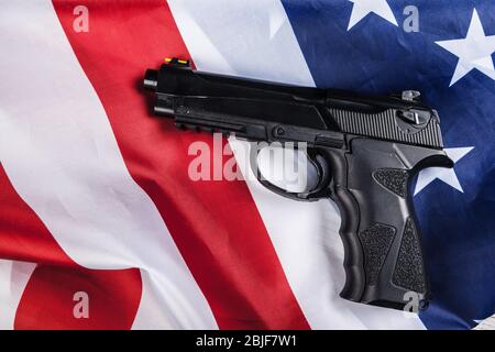 Handgun lying on American flag. Weapon problem concept Stock Photo