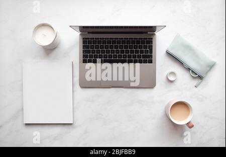 Top view of notebook and laptop on white desk with a cup of coffee. Stock Photo