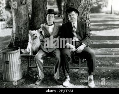 Laurel and Hardy sitting on a park bench in a scene from a classic silent comedy short subject, 'Early to Bed', 1928 from MGM. Stock Photo