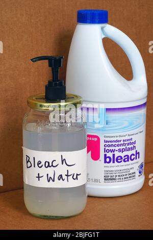 WEST WINDSOR, NJ -27 APR 2020- View of a bottle of bleach and a jar of bleach diluted in water during the COVID-19 pandemic. Stock Photo