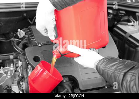 Male hands pouring engine oil from canister, closeup Stock Photo