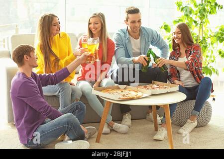 Friends with tasty pizza and beer at home party Stock Photo