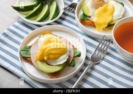 Plates with tasty eggs Benedict on table Stock Photo