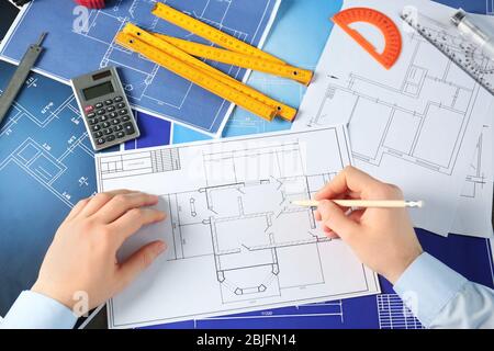 Male engineer hands working with blueprints on table Stock Photo
