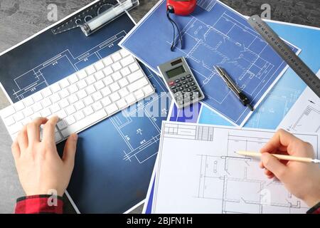 Male engineer hands working with blueprints on table Stock Photo