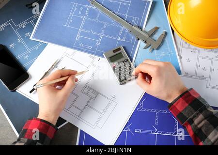 Male engineer hands working with blueprints on table Stock Photo