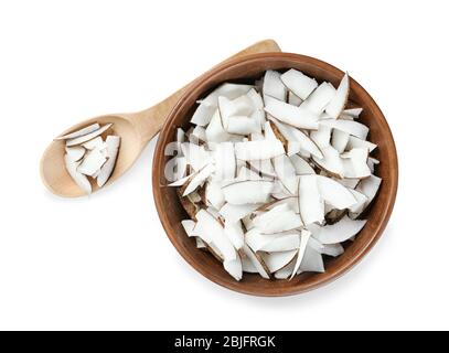Coconut pieces in bowl and wooden spoon on white background Stock Photo