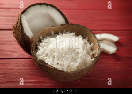 Grated coconut in shell on wooden background Stock Photo