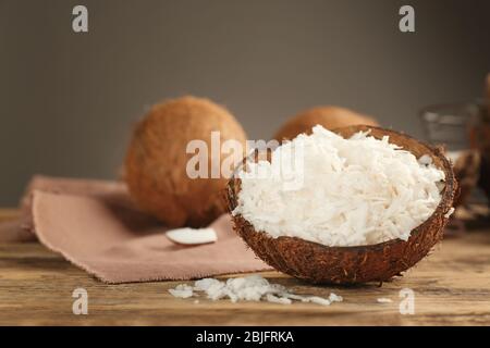 Grated coconut in shell on wooden table Stock Photo