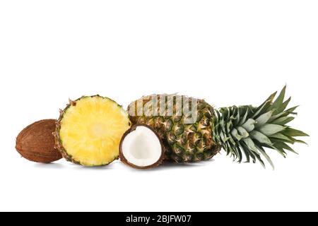 Fresh pineapples and coconuts on white background Stock Photo