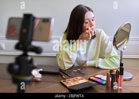 Teenage girl, beauty blogger filming video for channel blog, eyeshadow painting Stock Photo