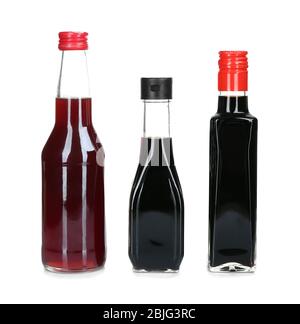 Glass bottles of liquid sauces isolated on white Stock Photo