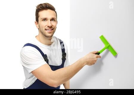 Young window cleaner with poster on white background Stock Photo