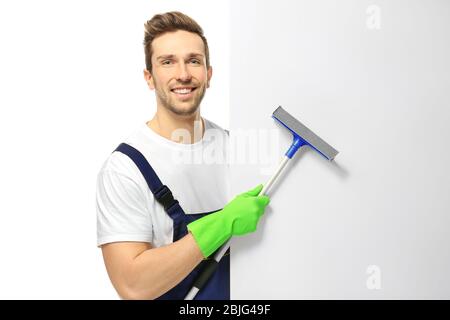 Young window cleaner with poster on white background Stock Photo