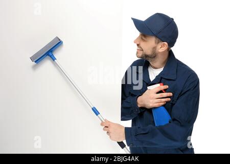 Young window cleaner with poster on white background Stock Photo