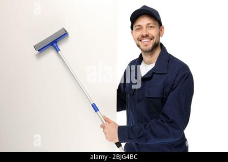 Young window cleaner with poster on white background Stock Photo